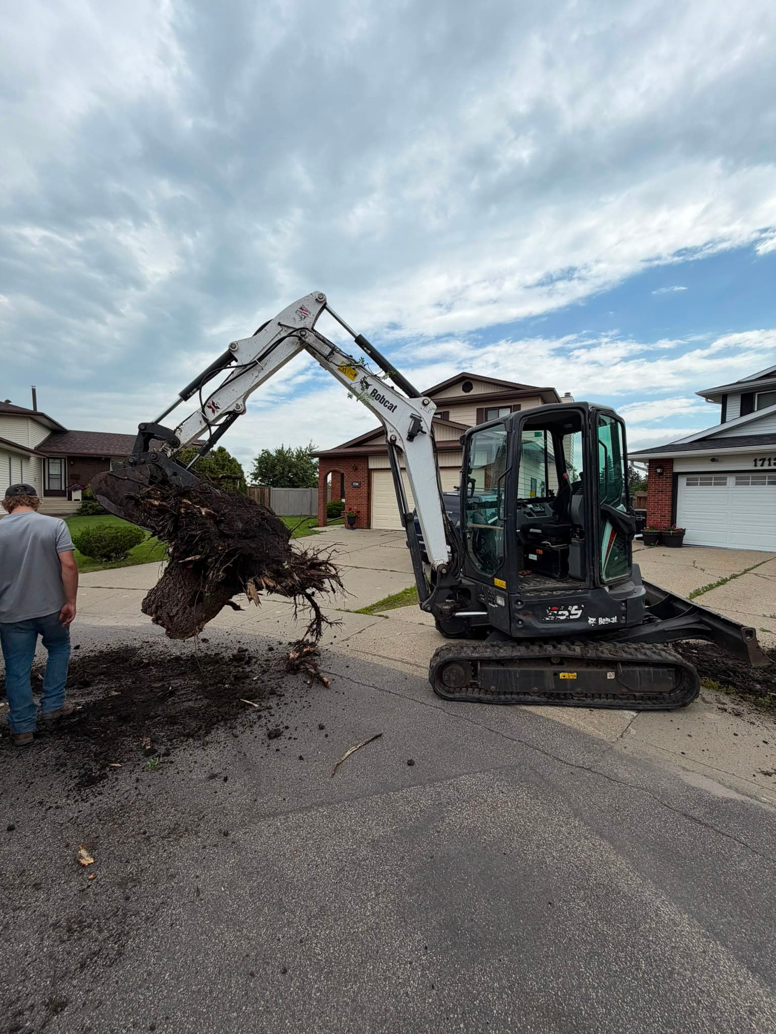 Kilt Contracting Bobcat E35 removing a tree stump in Edmonton